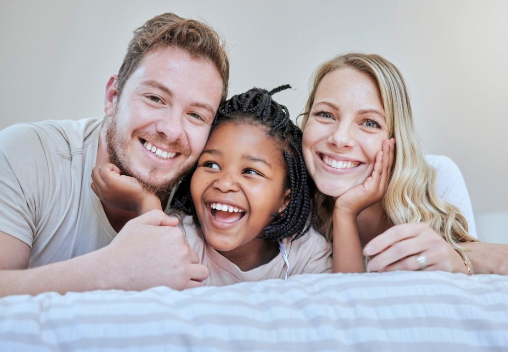 Diversity, happy family or foster parents in bedroom relax, happy or family love portrait in house